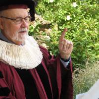 Dean Antczak in academic regalia and an Elizabethan ruff reading the proclamation